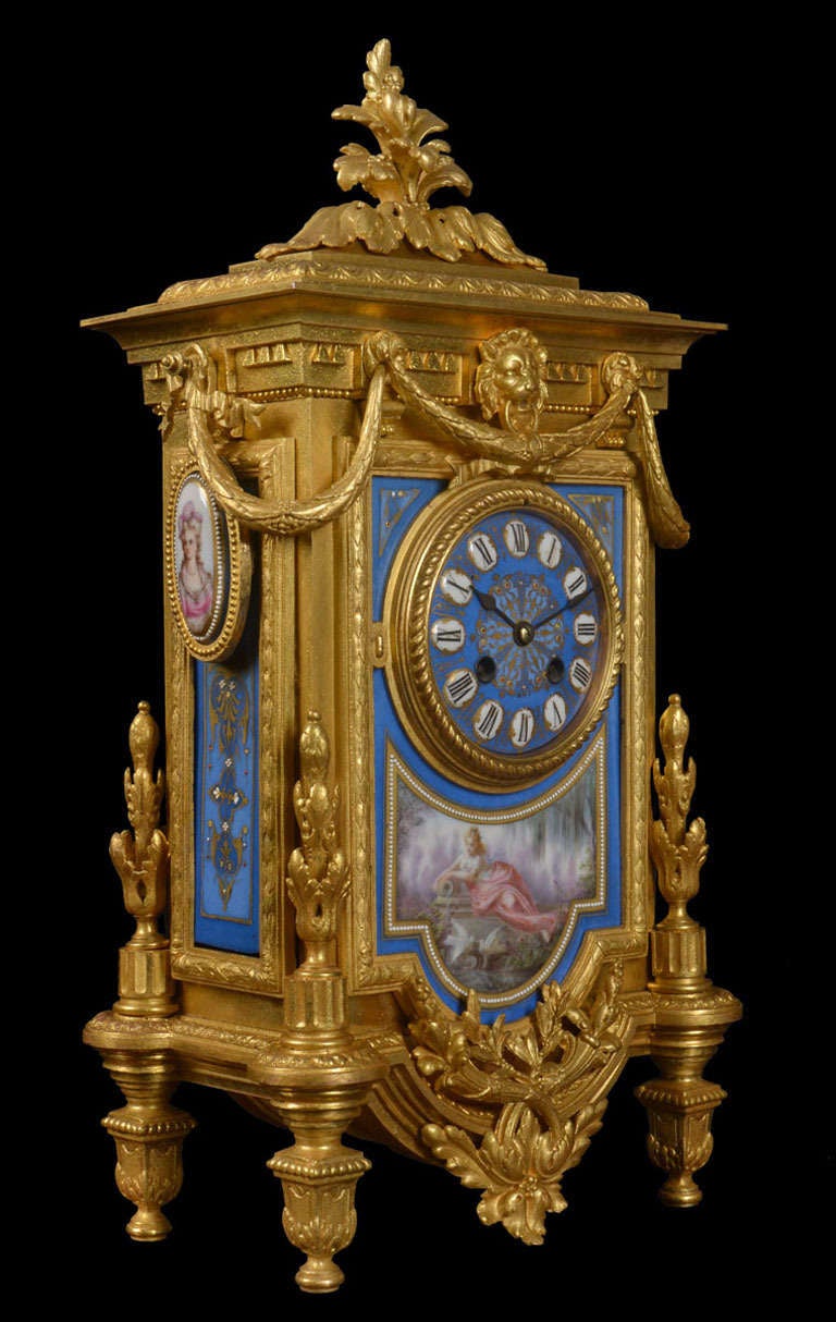French Louis XVI style gilt metal mantel clock, having blue porcelain dial and panels, and applied portrait medallions, in an upright case with swag and leaf decoration the eight-day movement striking the hour and half hour on a bell the movement