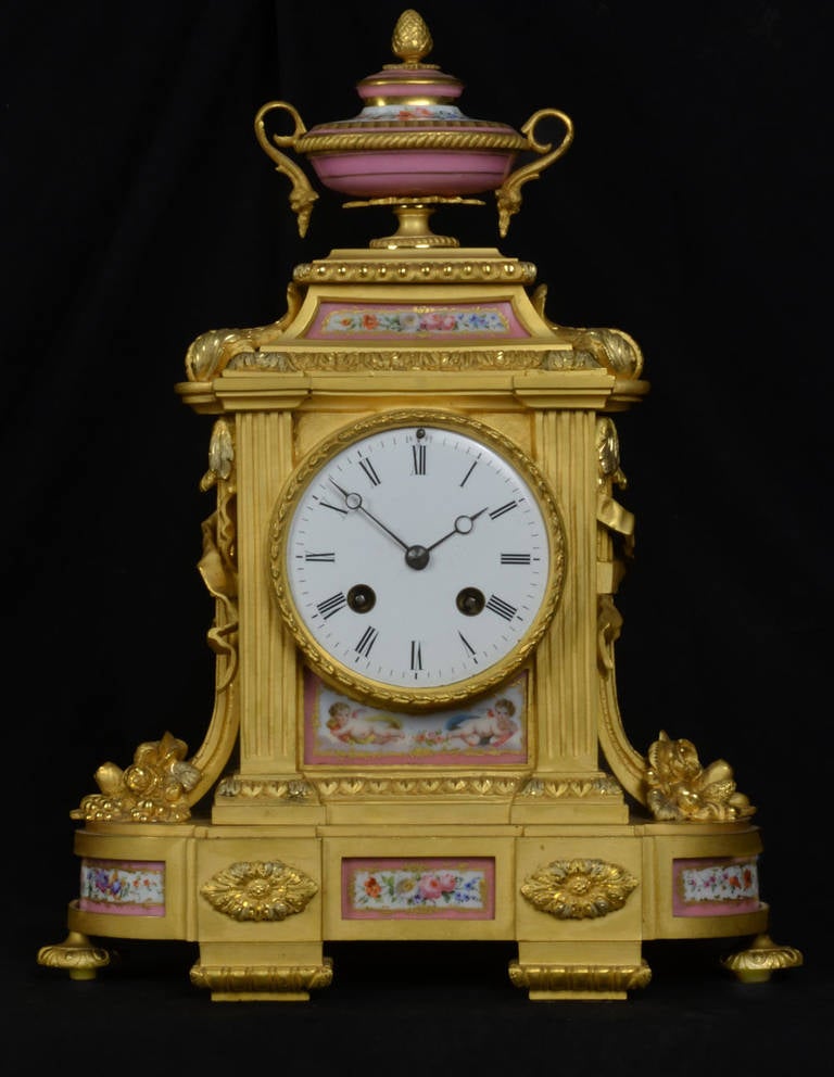 French gilt bronze mantel clock with serves panels the case with painted porcelain dial and panels the eight-day movement striking on a bell. In full working order.