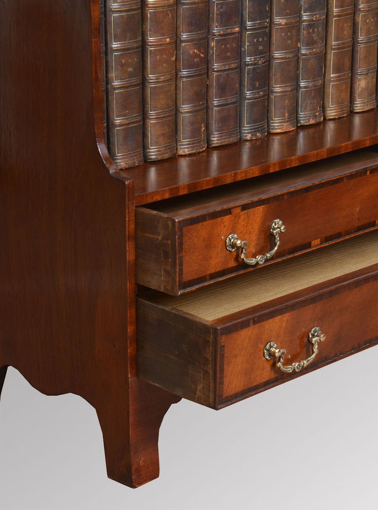 Pair of Edwardian mahogany waterfall opens bookcases the four graduated fixed shelves above two short drawers with brass drop handles raised up on shaped feet