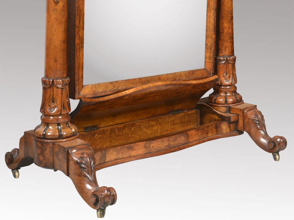 Burr walnut cheval mirror, of arched rectangular form, the circular columns capped with acanthus capitals, the large plate mirror enclosed in walnut frame. The base with secret lift up lidded compartment, raised up on scrolling cabriole legs