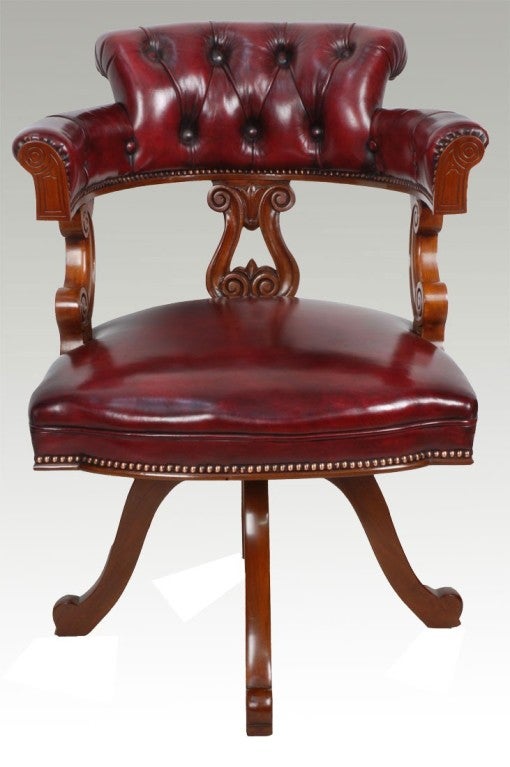 Victorian mahogany swivel office chair, with shaped wraparound  back, above burgundy leather upholstered seat, raised on four arched scroll toe supports