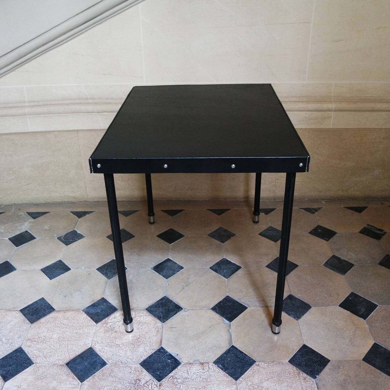 Nice and chic lady desk by Jacques Quinet in black leather hand-stitched, feet ended in brass.