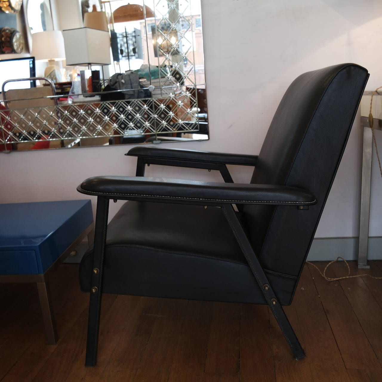 Two Jacques Quinet chairs re-covered with a black leather pique sellier hand-stitched with brass details.