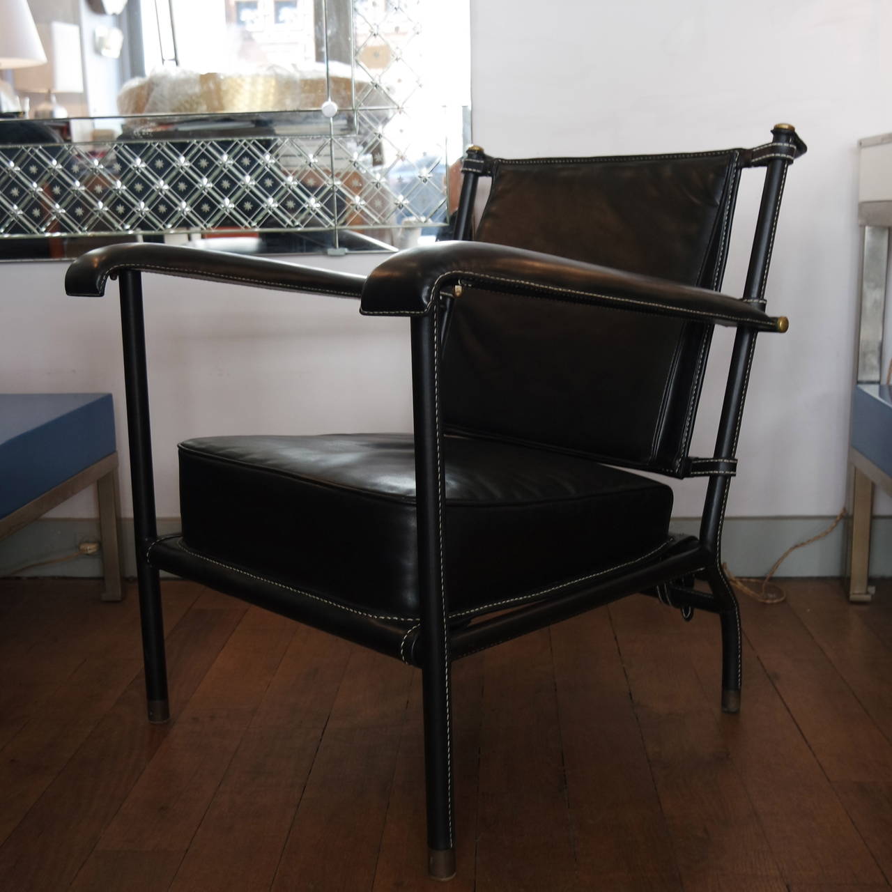 Beautiful and chic pair of Jacques Adnet armchairs with a belted back.
Covered with a black leather hand-stitched piqué-sellier, metal structure gained by leather and ended in brass.