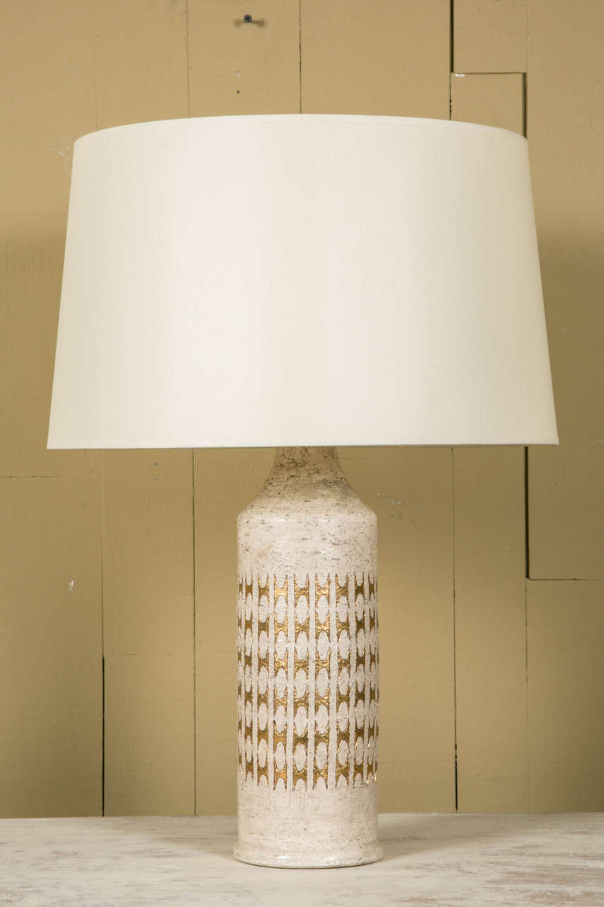 Pair of large Bergboms ivory and gold glazed ceramic table lamps, produced by Bitossi for Bergboms. 
They are signed and original labels are present and have a beautiful rich gilded shine when lightened
Shades are in ivory silk.

(Note that size