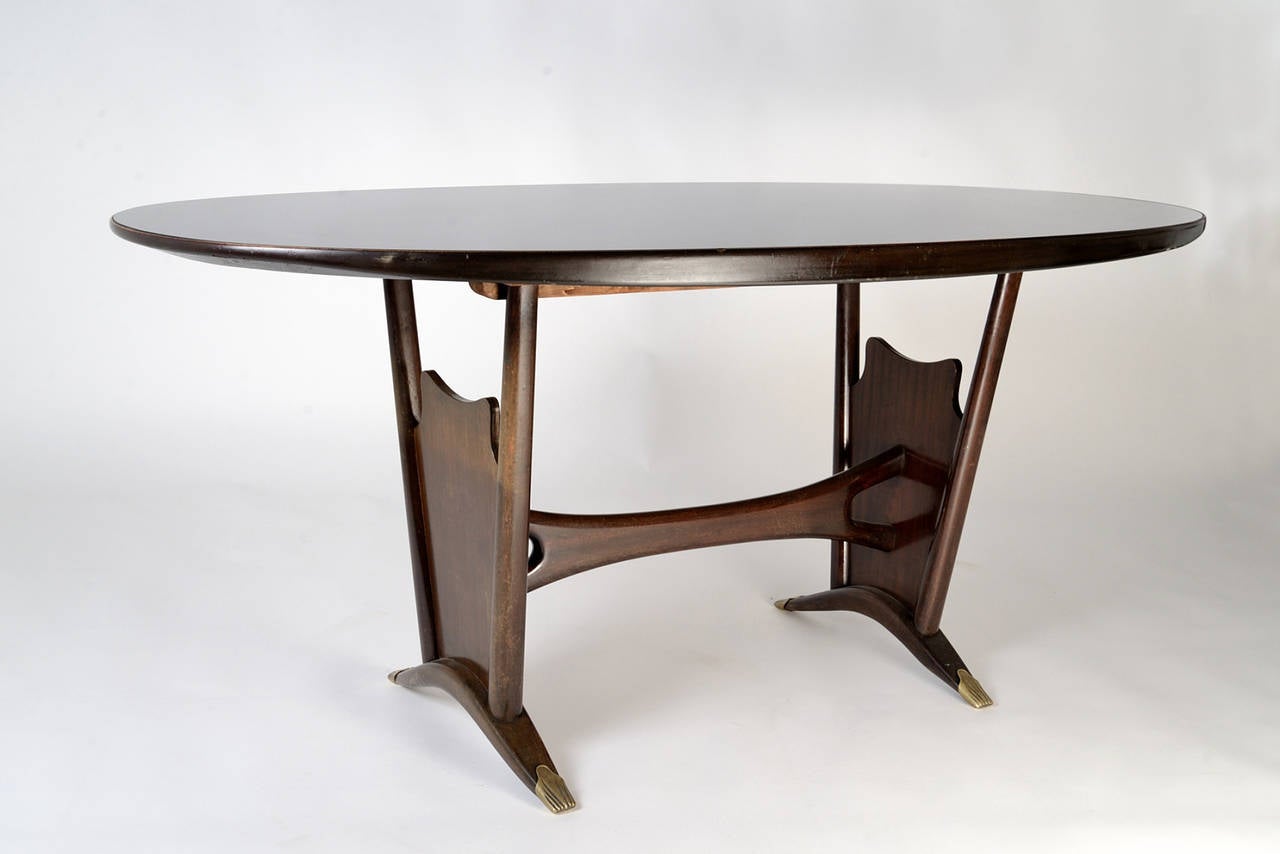 Exquisite table in the style of Cesare Lacca, manufactured in Italy in the 1940s. Wooden structure with brass sabots, wooden top with a black opaline glass sheet inserted in it.