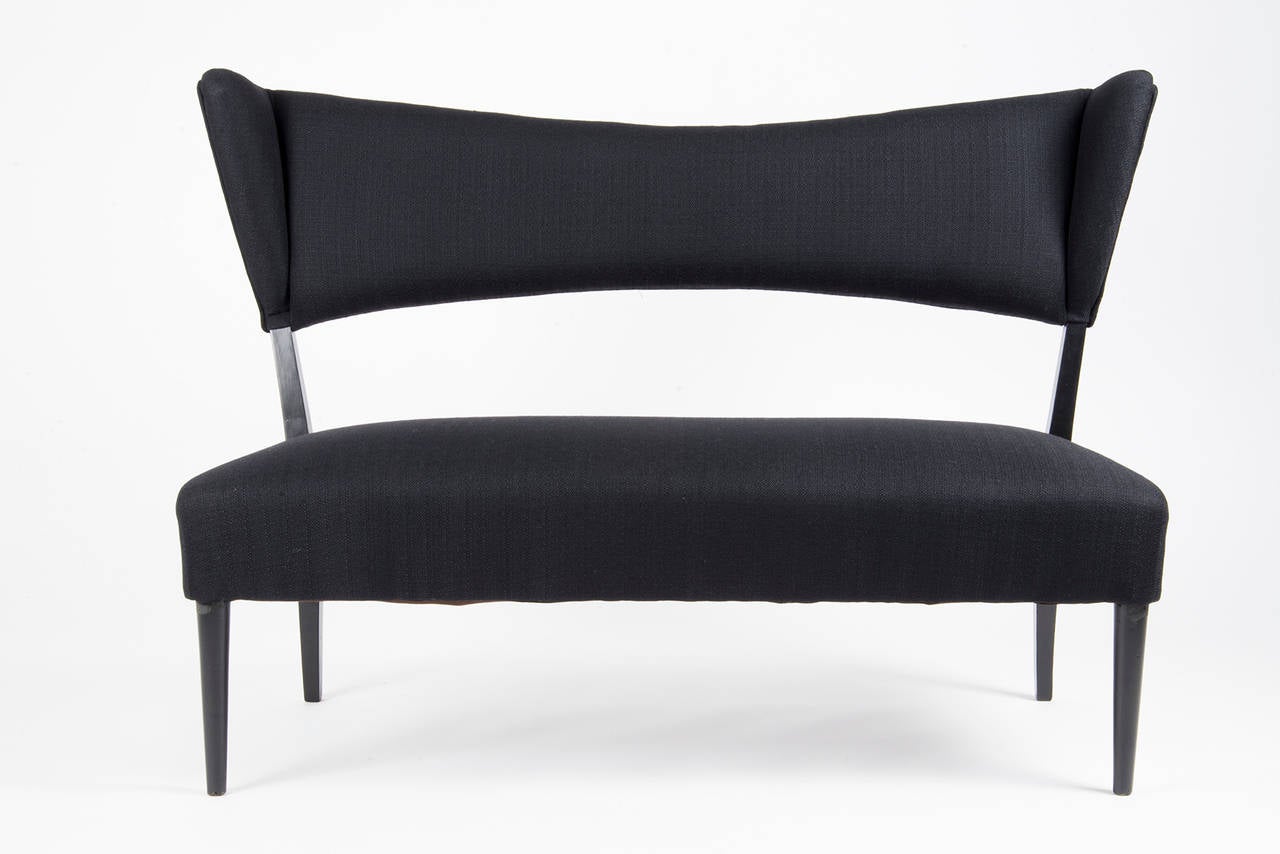 Extraordinarily elegant settee manufactured in Italy in the 1950s. Black lacquered wooden structure with curved back feet, upholstery covered with black cotton fabric. Re-upholstered, very good conditions.