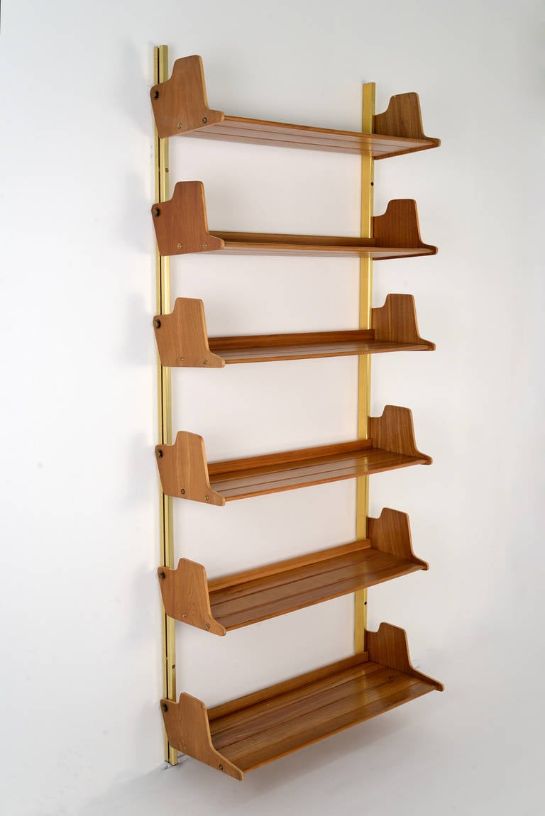 E60 bookcase designed by Osvaldo Borsani, manufactured by Tecno in 1953. Customizable wooden shelves, brass structure and screws. The lower shelf is bigger and is cm 38,5 deep.