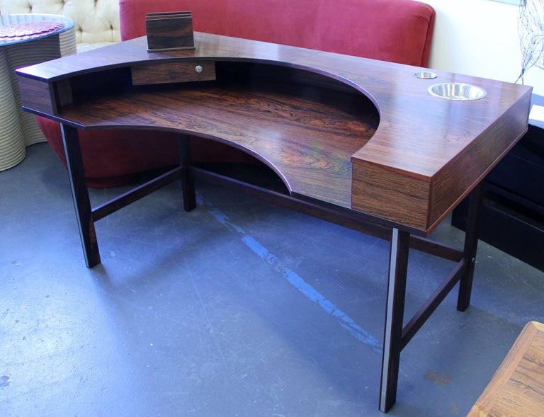 A unique and rare Danish modern rosewood desk with the Lovig Dansk Design Denmark brand. This desk retains the original stainless steel storage inserts and the movable rosewood letter file. It also has a locking drawer with original key. We have not