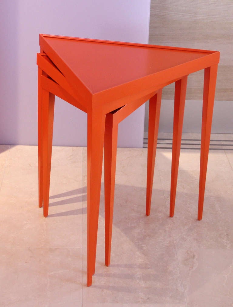 Unique set of three bright orange  nesting tables. Recently refinished and painted. Measurements are for the largest table only.