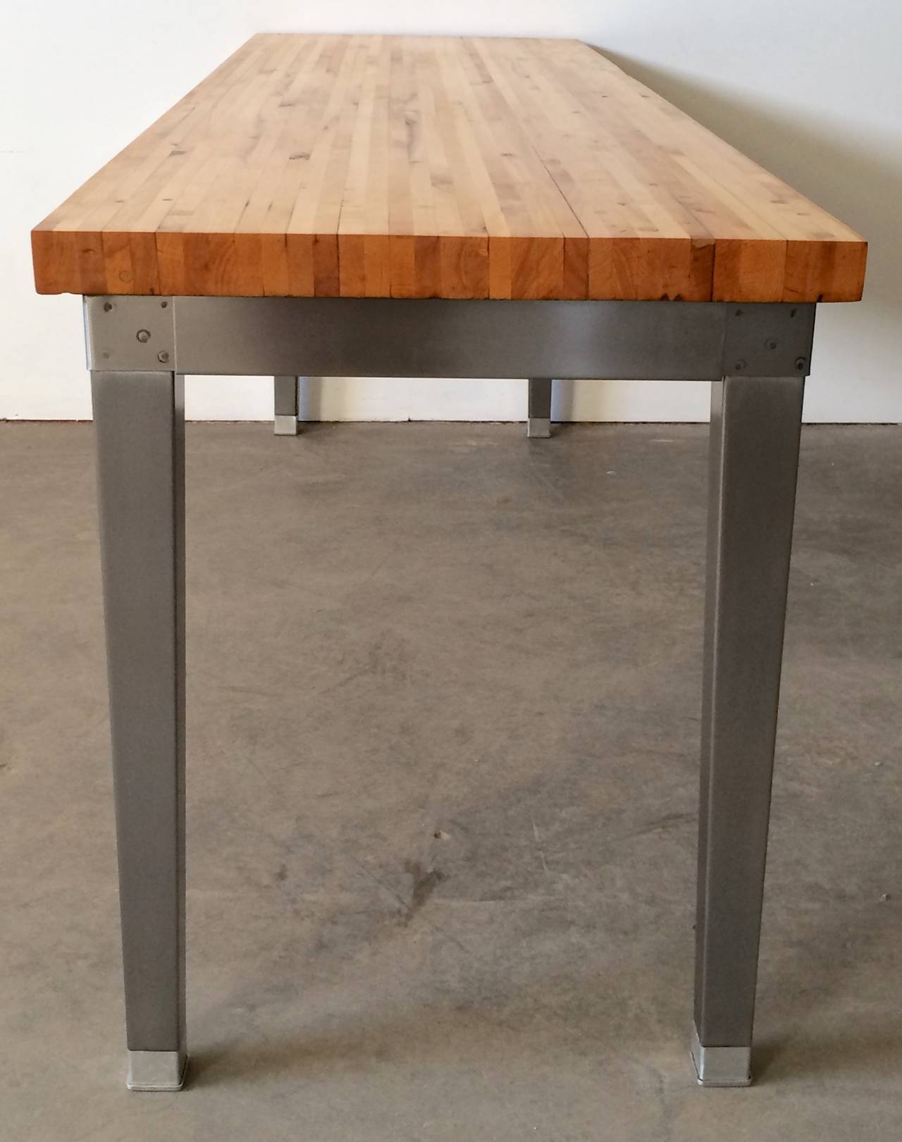 A vintage Industrial style maple butcher block table with metal legs. Completely restored and ready for a variety of uses. It works well as a serving or console table, a work table, desk or even a intimate dining table.