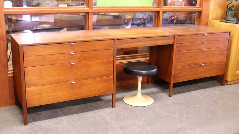 Three piece Florence Knoll for Knoll bedroom set with a pair of walnut 4-drawer chests and removable walnut vanity/dressing table insert. Saarrinen for Knoll stool is also included. All with early Knoll labels.