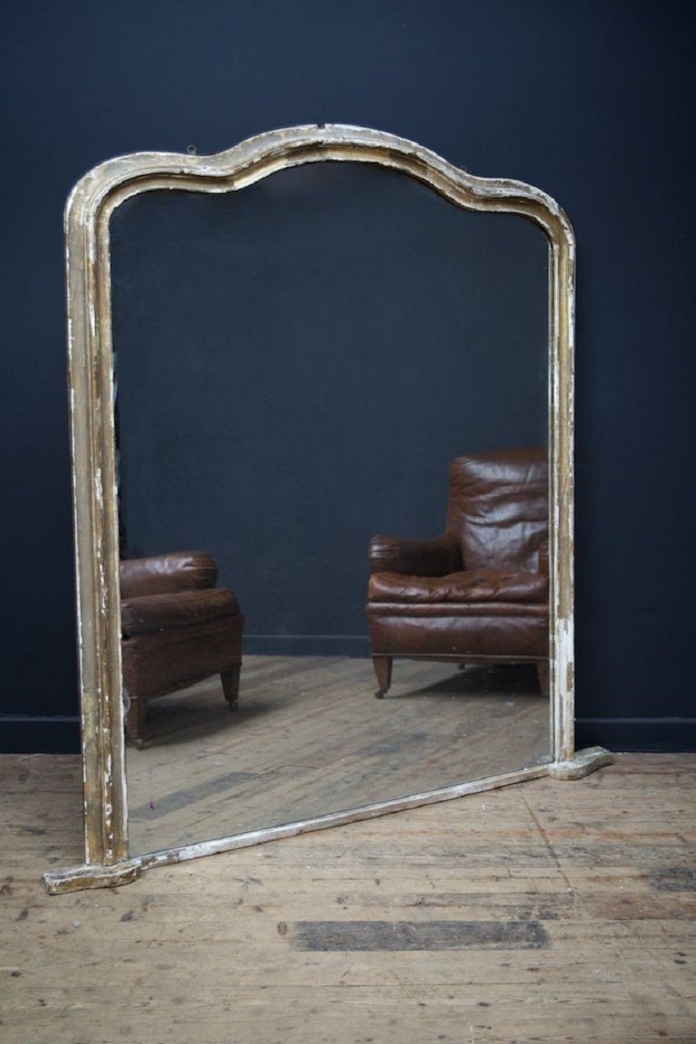 Large over mantle mirror with serpentine top rail. 

Beautifully worn gilding to the frame, lightly distressed mirror plate, original backboards. 

English late 19th century. 

H: 162 W:132 D:7 CM