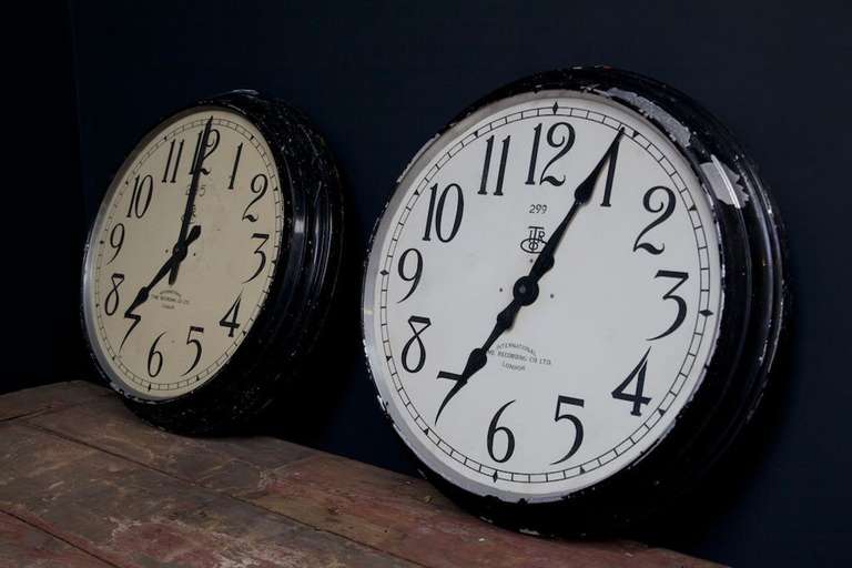 A pair of large factory slave clocks, manufactured by the 