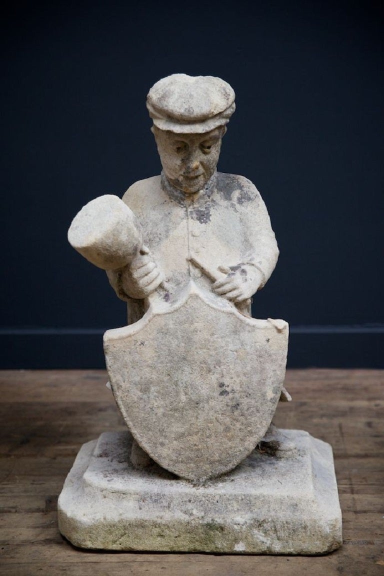 A pair of expressive carved stone figures both in late 19th century dress. 

Male figure shown as a stone mason carving a shield, the female figure presenting a scroll and wreath, both on a squared base. 

Rare and exceptionally original.