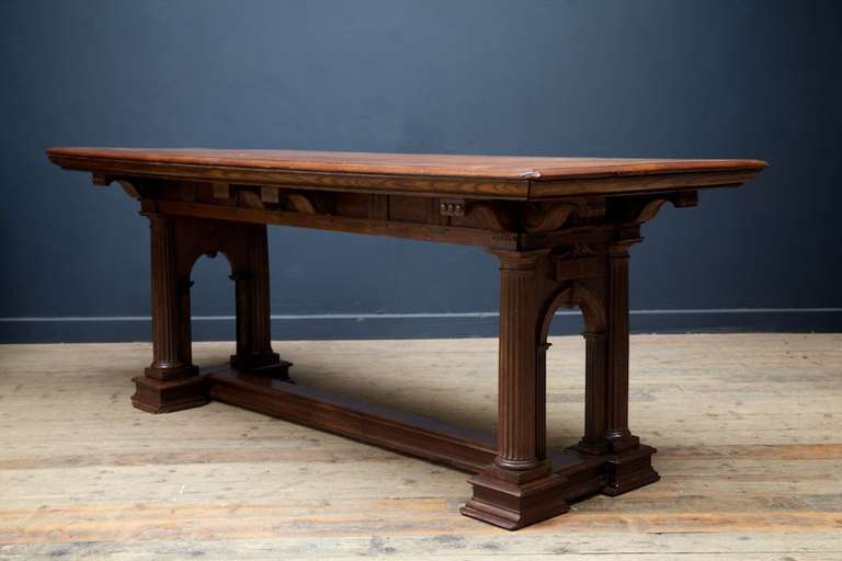 A oak centre table of architectural form.
Fluted column supports, low stretcher, scrolled bracket supports to top.
Masculine and unrestored.
English 1870s.