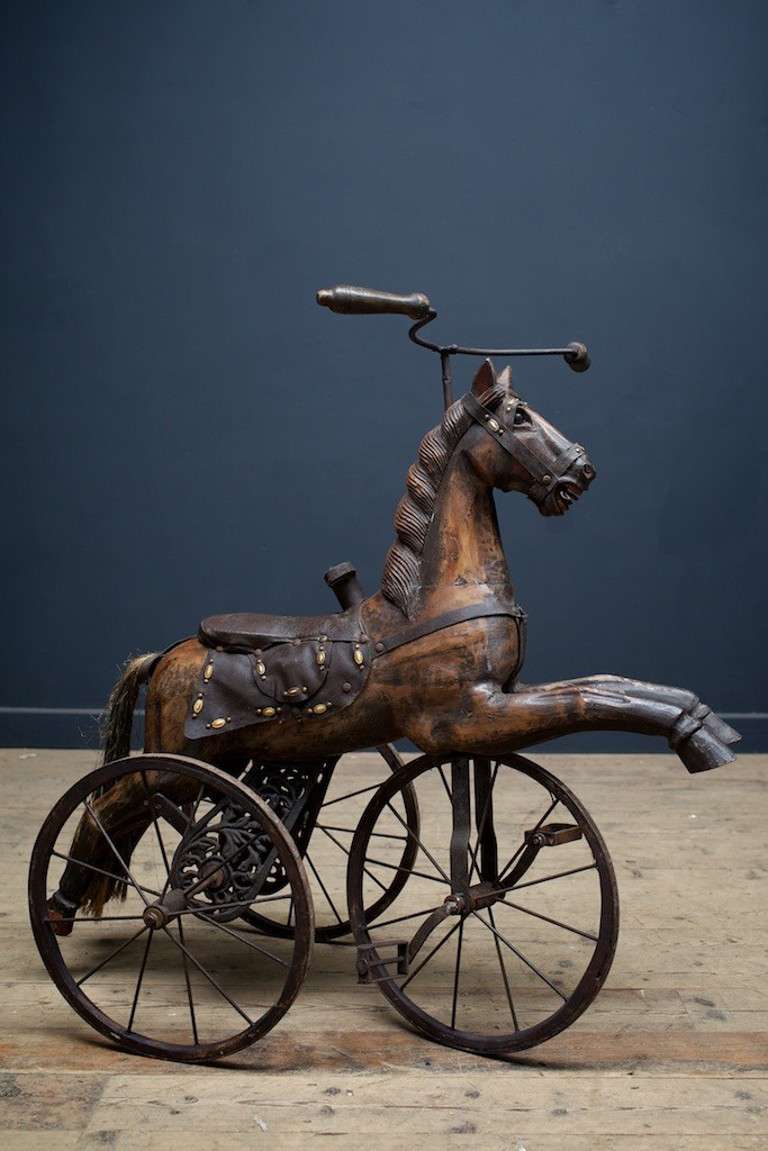 Late 19th Century French carved wood tricycle in good painted original condition on cast iron supports. Leather bridle and decorated sadle.