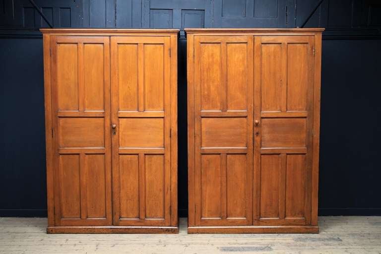 A pair of painted oak Estate cupboards. 
Excellent original condition. 
Solid oak panelled doors and case with original locks and handles, pitch pine back boards and shelves. 
English, Circa 1900. 
Price is for the pair.