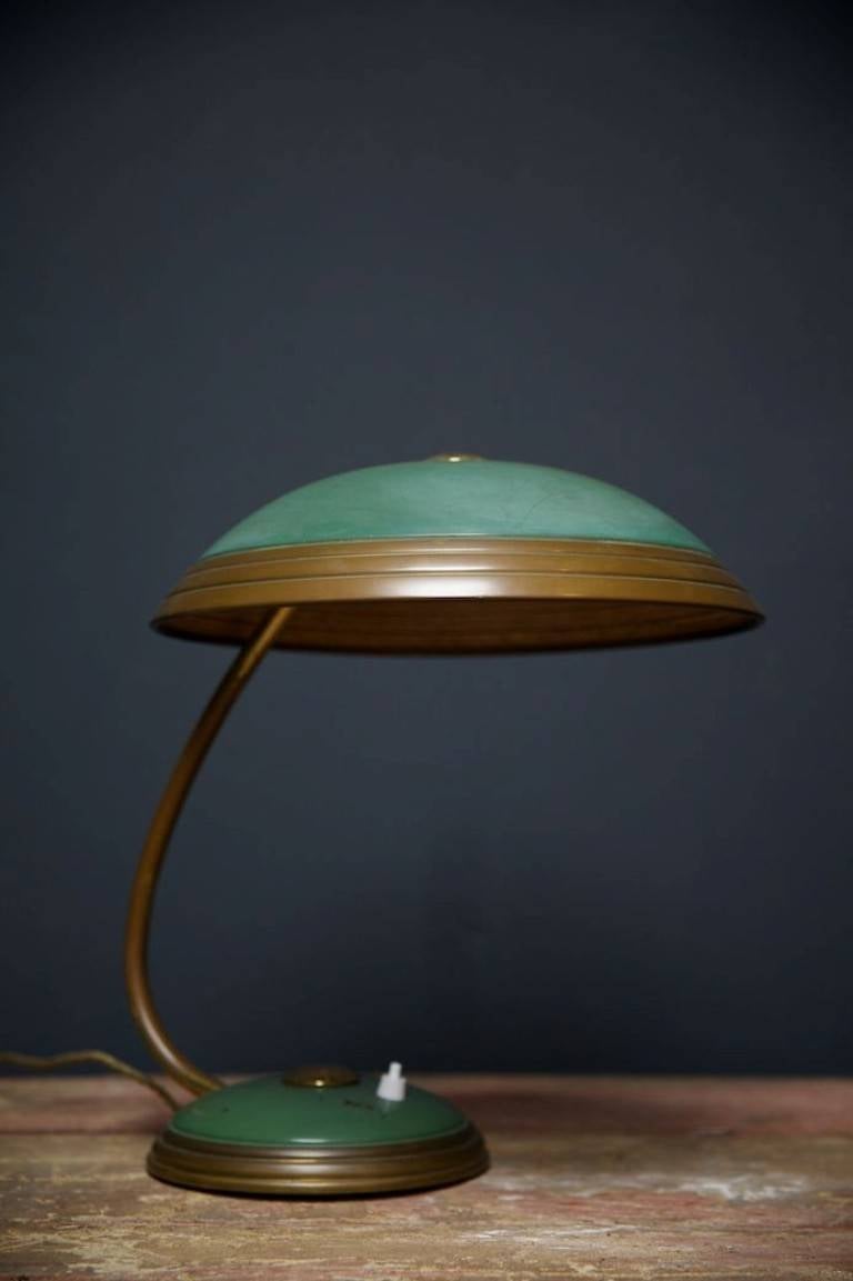 A patinated green lacquer and brass desk lamp by 