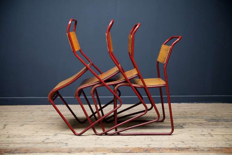 We have a run of ten of these iconic Cox stacking chairs. 
Red tubulur frames with ply seat and back. 
English, 1950s 
Price per chair.