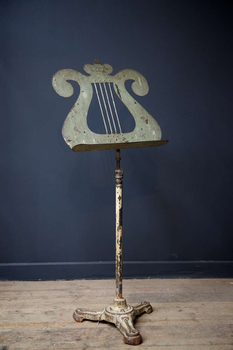A cast iron music stand. 
Tripod base, lyre fashioned stand, height adjustable with great worn painted finish. 
English, Late 19th centtury. 
Two available, price per stand.