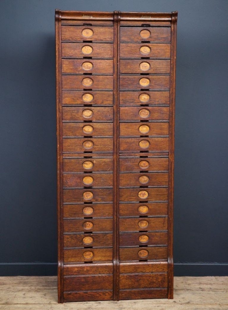 A tall oak two section filing cabinet manufactured by and marked Amberg. 

American 1910. 

H: 194 W:79 D:32 CM