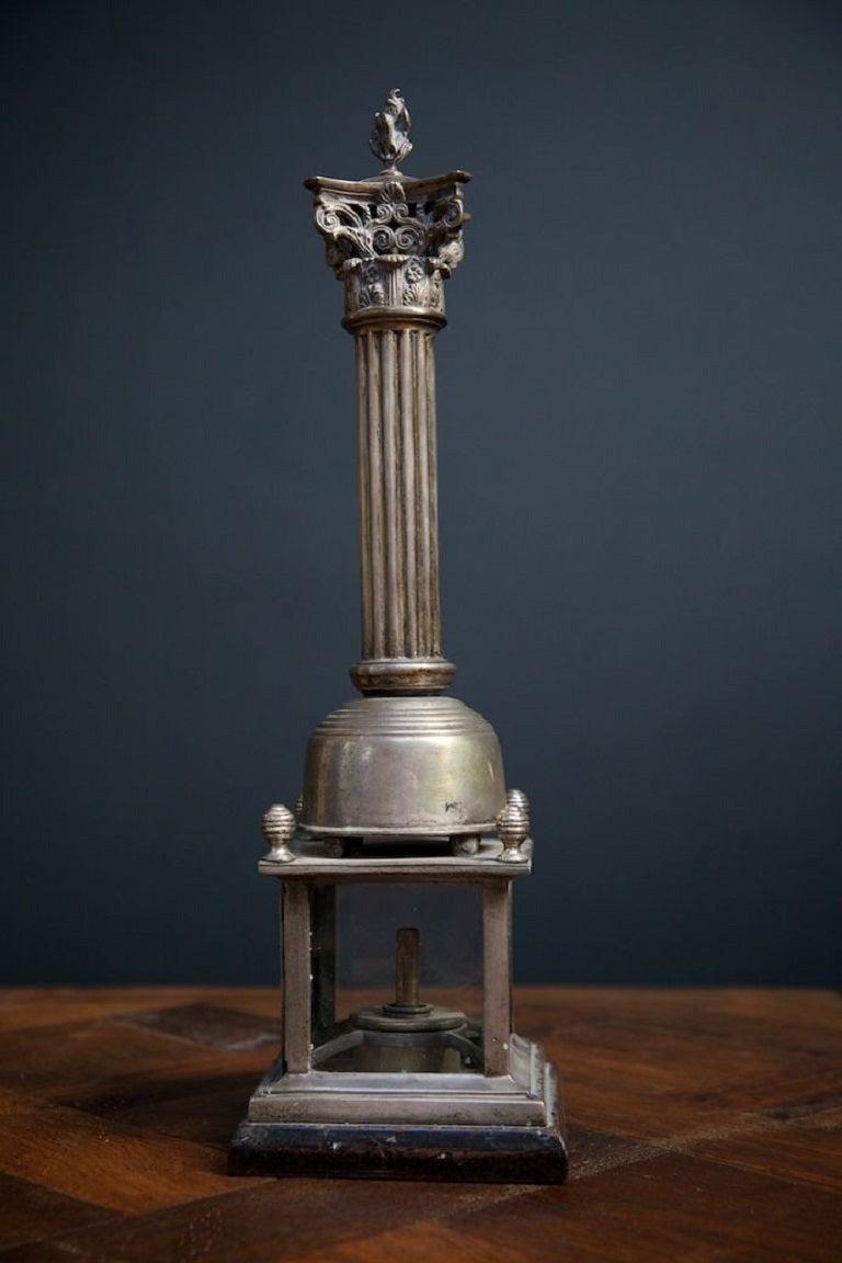 A nickel plated 19th century corinthium column lamp base with unusual glass base with door. 

English 1840s. 

H: 52 W: 15 D:15 CM