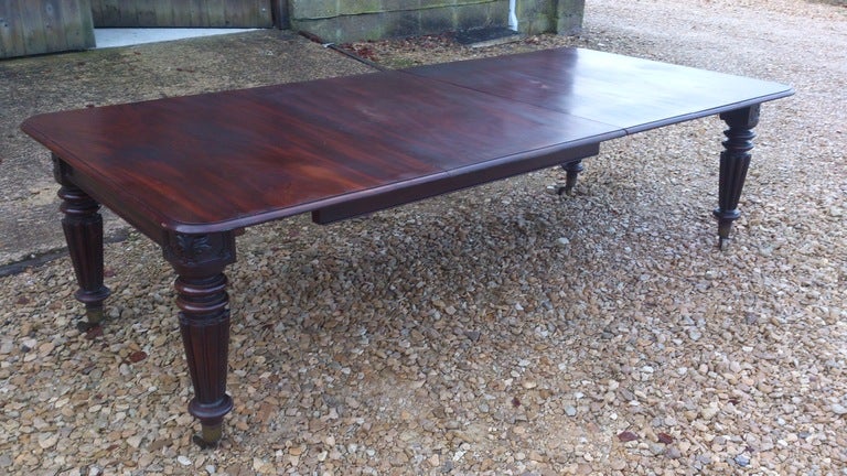 Good solid antique extending dining table. This table is made of very dense grained Cuban mahogany which has an interesting grain pattern. The mechanism of the table is so strong that it only needs four legs to support it. That means that none of