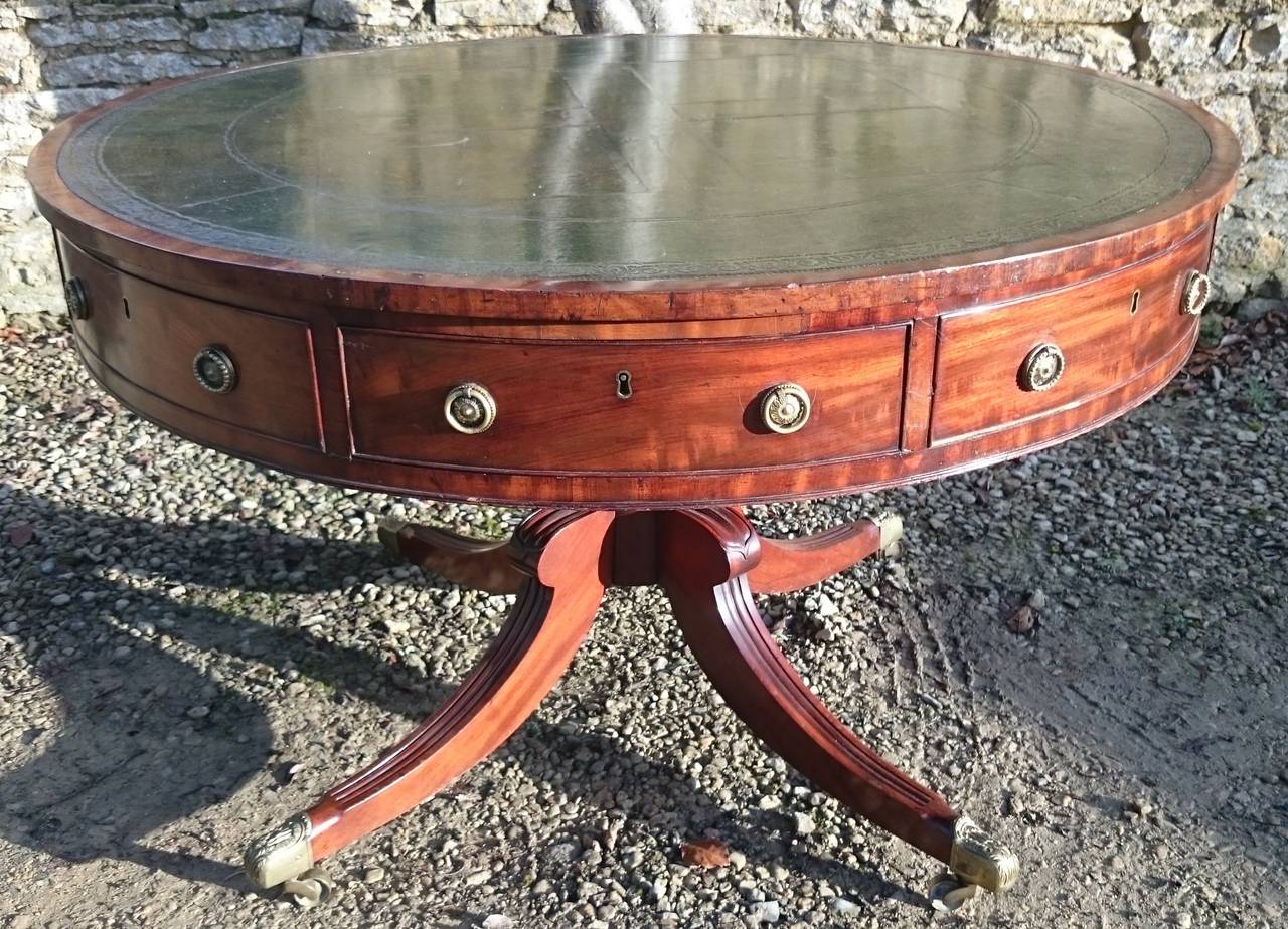 Regency mahogany antique drum table with rotating top and alternating real and false drawers around the edge. This table is made of an especially fine cut of mahogany which has the appearance of satinwood when viewed in sunlight. 

English circa