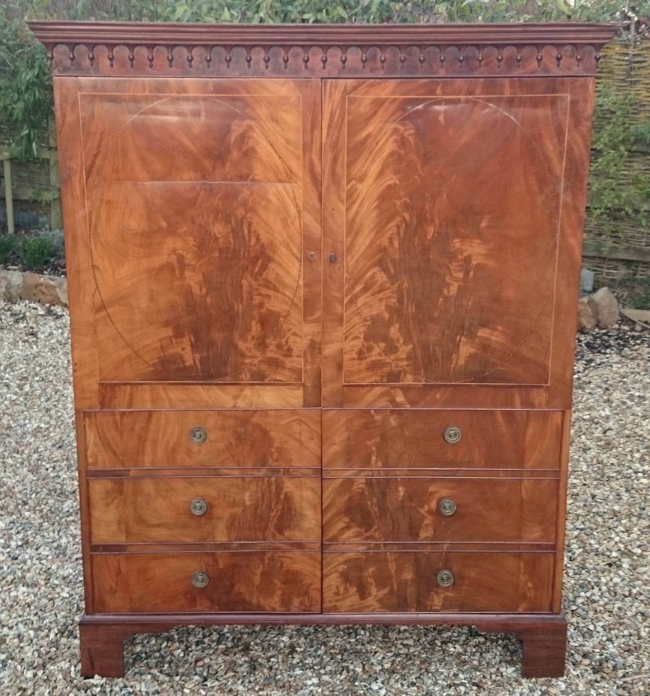Antique wardrobe that looks like an antique linen press. This wardrobe has false drawers to make it look like a linen press, presumably because it had a pair that was a linen press, but we may never solve this mystery for sure. The timber is flame
