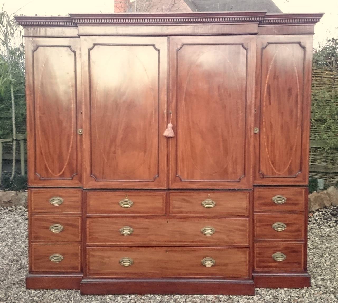 Antique wardrobe with full length hanging either end and half length hanging space in the centre converted from linen press for shirts, jackets and trousers. 
This is a magnificent piece of furniture made of fine figured mahogany with cross banding