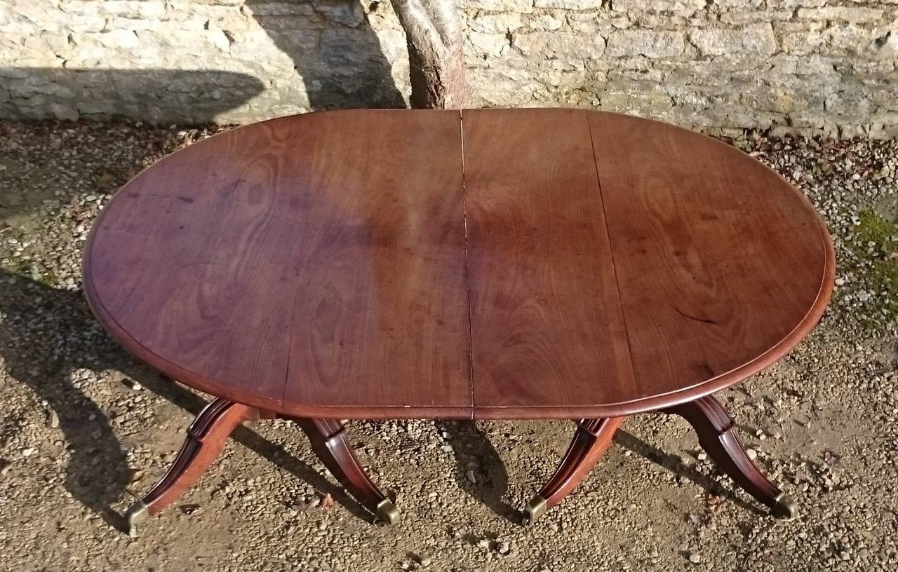 Antique twin pillar dining table. This table is a tremendous scale with very generous splay to the legs and huge reeded columns made of a single piece of mahogany. The top is made of huge sheets of dense grained slow growing Cuban mahogany. The