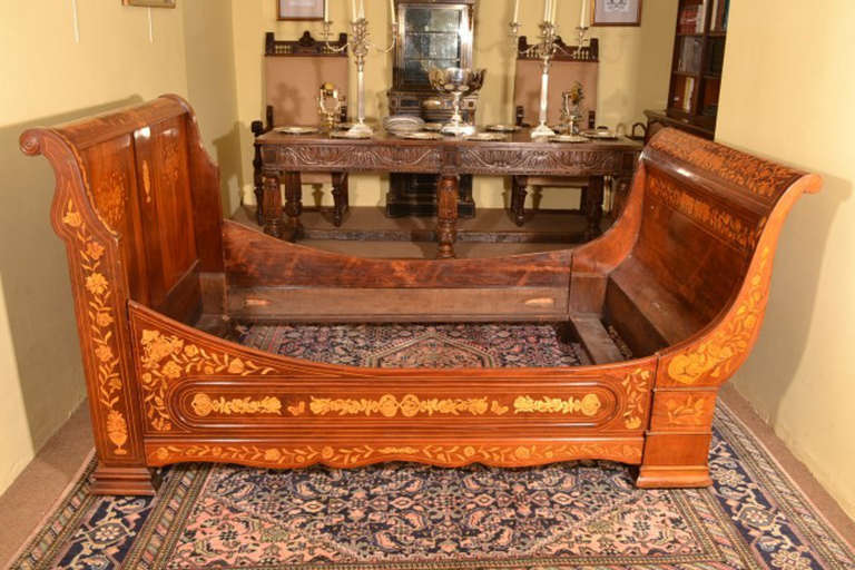 This is a lovely antique Dutch mahogany and marquetry daybed, circa 1830 in date. 

The bed has scrolling head and footboards. There are lovely floral marquetry decorations throughout and conforming stretchers. 

The bed can be used as a day bed