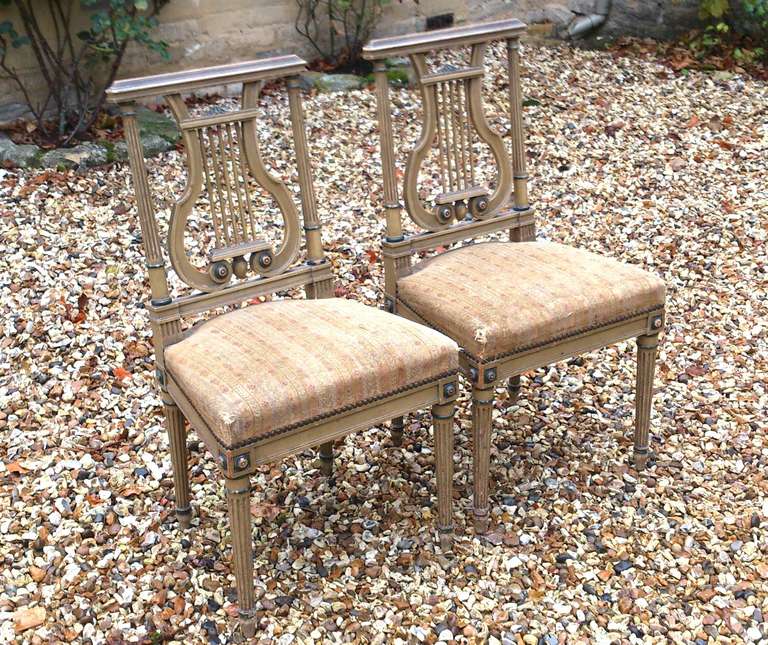 Charming pair of painted antique chairs are French and date from the late 19th century. The paint has worn in to just the right degree and the design is restrained with clean lines and lyre support on the backrest. 

French circa 1890 

18 1/2