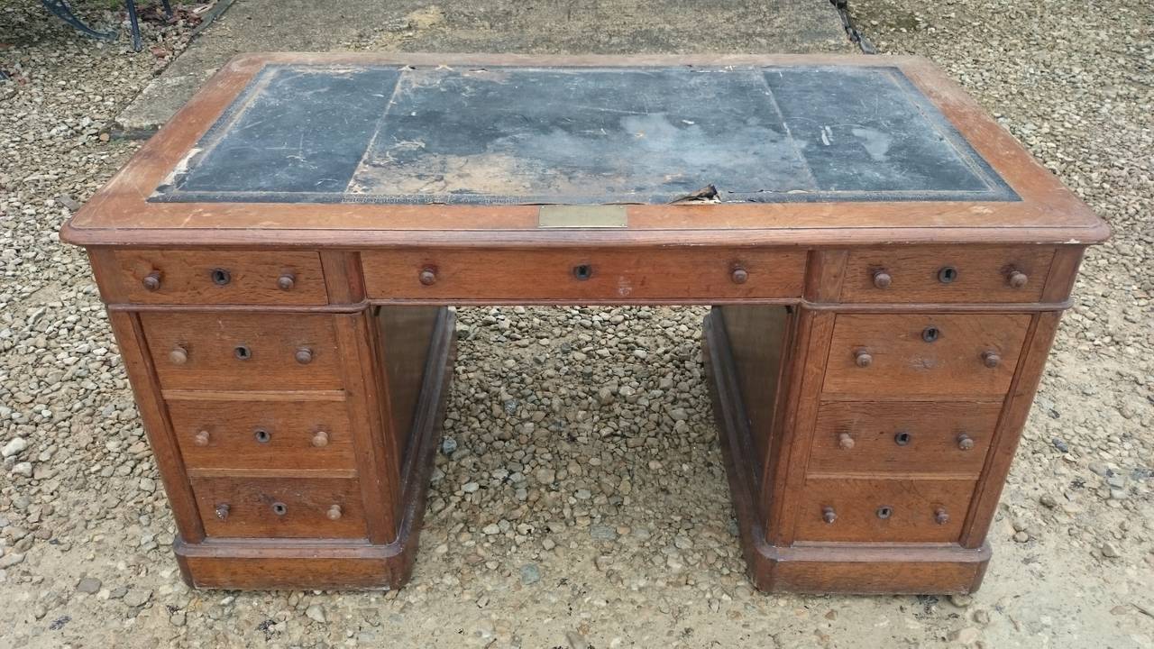 Antique pedestal desk made of very dense grained oak. This desk is extremely well made with precision construction in every aspect of the design. There are drawers on one side and the desk is properly finished to the reverse so that it can stand