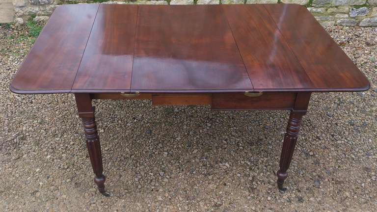 An unusual and versatile extending Pembroke table with removable leaf. The legs are especially slender and the frieze narrow on this early 19th century model. It is made of good interesting dense grained mahogany and is a very solid and practical