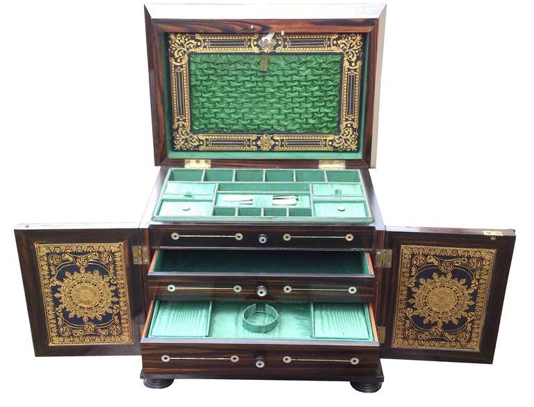 A 'Pagoda' style table top ladies compendium or cabinet made of Coromandel with extensive mother of pearl decoration to the top front and the inside.

Two doors to the front open to reveal three drawers for jewellery. The lower drawer hides a pull