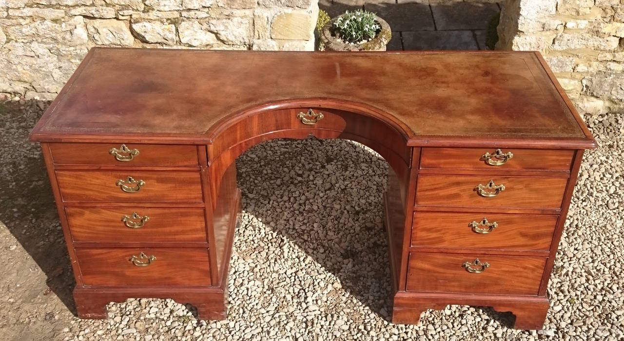 Antique desk made of exceptionally fine mahogany with concave front and old green skiver. The quality and construction of this desk are second to none, slide open the drawers and check out the dovetails inside. 

English circa 1770 
26