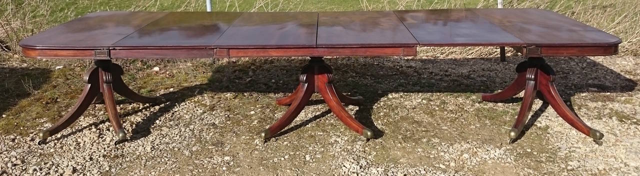 Antique three pedestal dining table with extremely unusual support mechanism. Each end of the table has two swinging arms which attach to the centre section. Almost unique at this early period, this enables the three pillars to support four floating