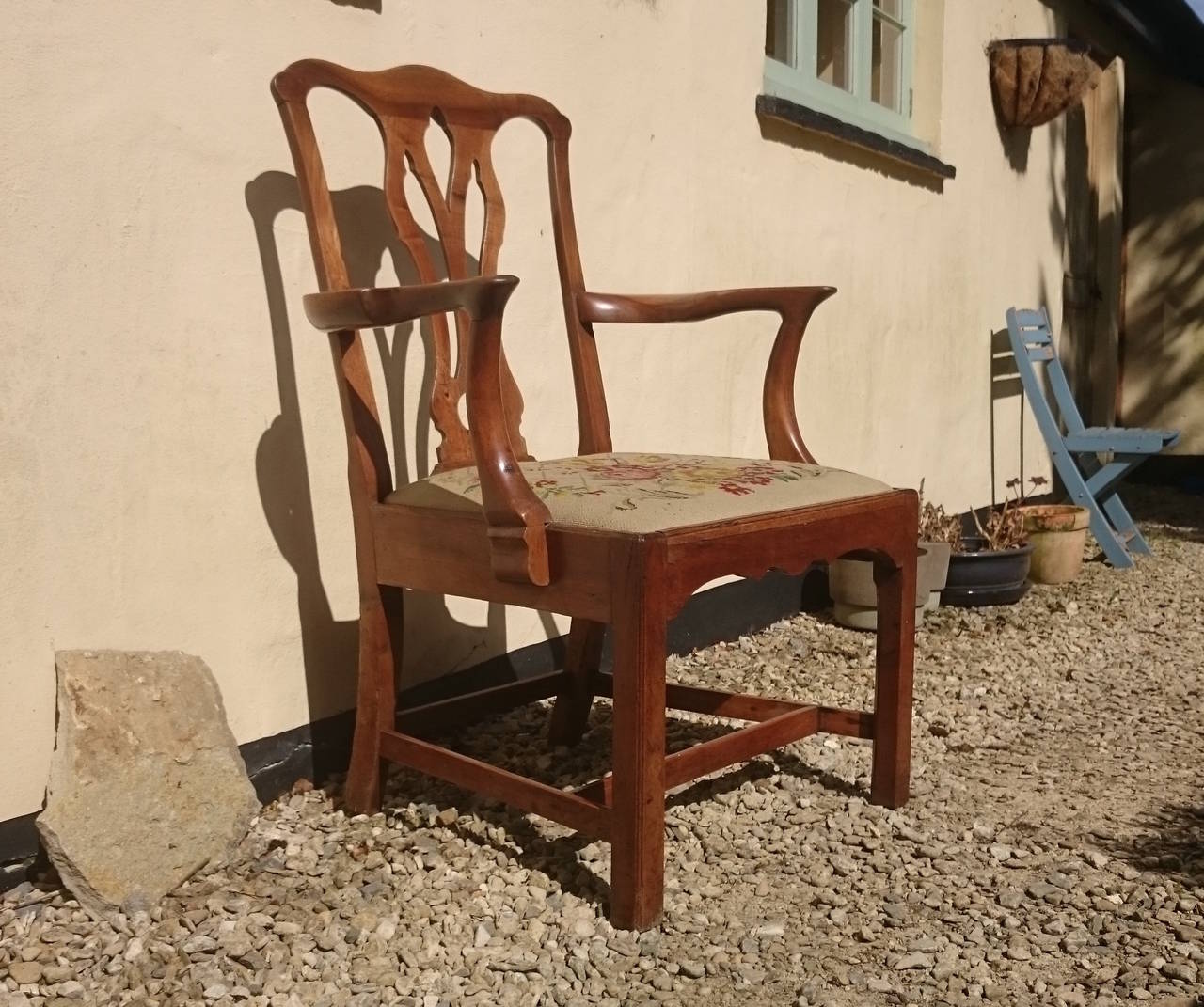 Early 18th century antique armchair made of walnut. This chair is a great scale and would be good in a library or behind a desk. This is a very old chair so there are some old repairs and some long dead wood worm in the show wood. If you are buying