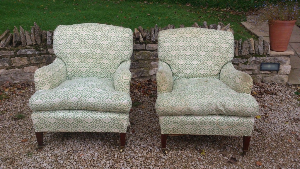 A fine pair of supremely comfortable armchairs made by Howard and Sons of London. These chairs are upholstered using the finest grade horsehair and pure down feathers. There is no foam or other post-war material used in the construction. Howard and