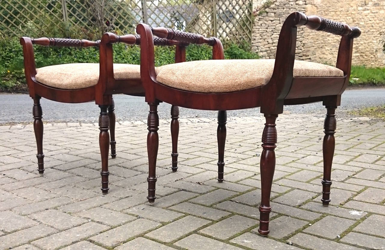 Pair of antique stools made of mahogany standing on turned legs and side rails. 

English circa 1820 

22