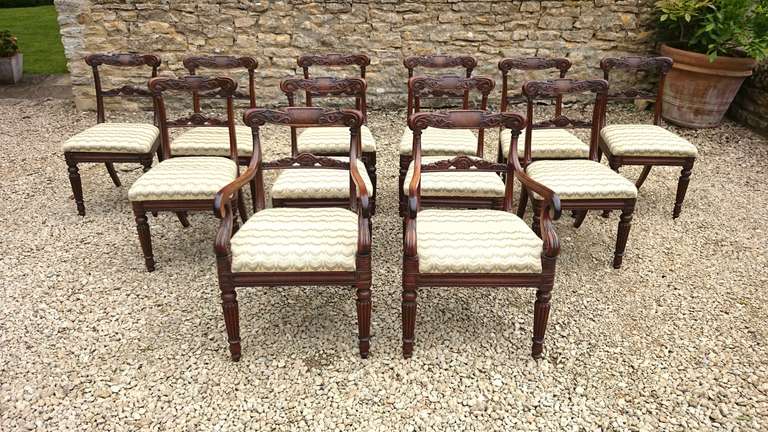 Very fine set of 12 antique dining chairs comprising two carvers and ten single dining chairs. This set of chairs are a generous shape with large sweep to the back lags, deep seat and fine crisp carving. There are many aspects to their design that