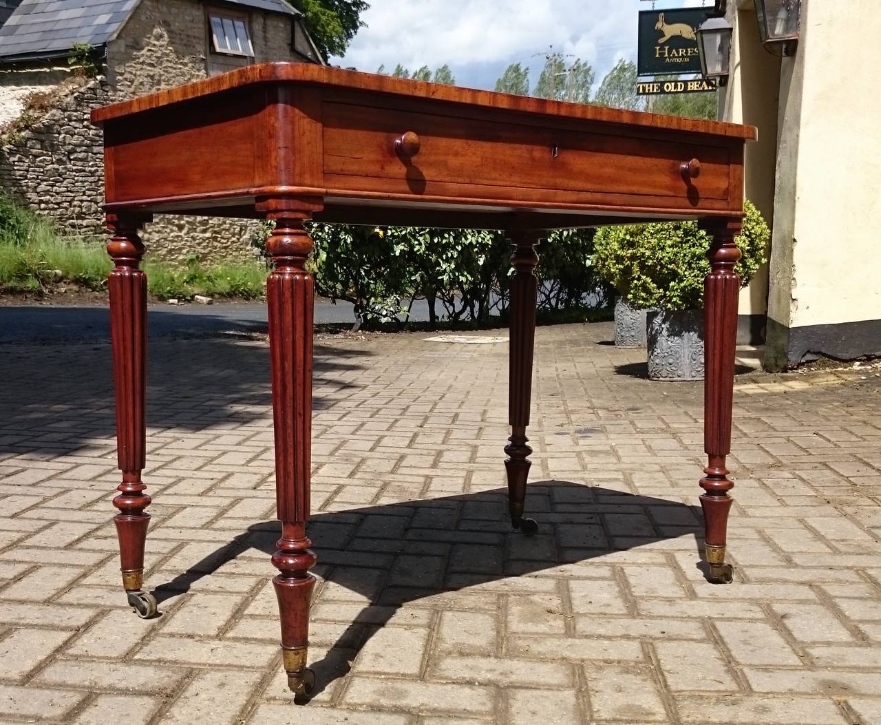 Antique writing table made by Gillow of Lancaster and London. This table has old leather top with recessed section covered by lift up lid to hide inks. The drawer is constructed with precision hand cut dovetails and the leg is the classic leg from