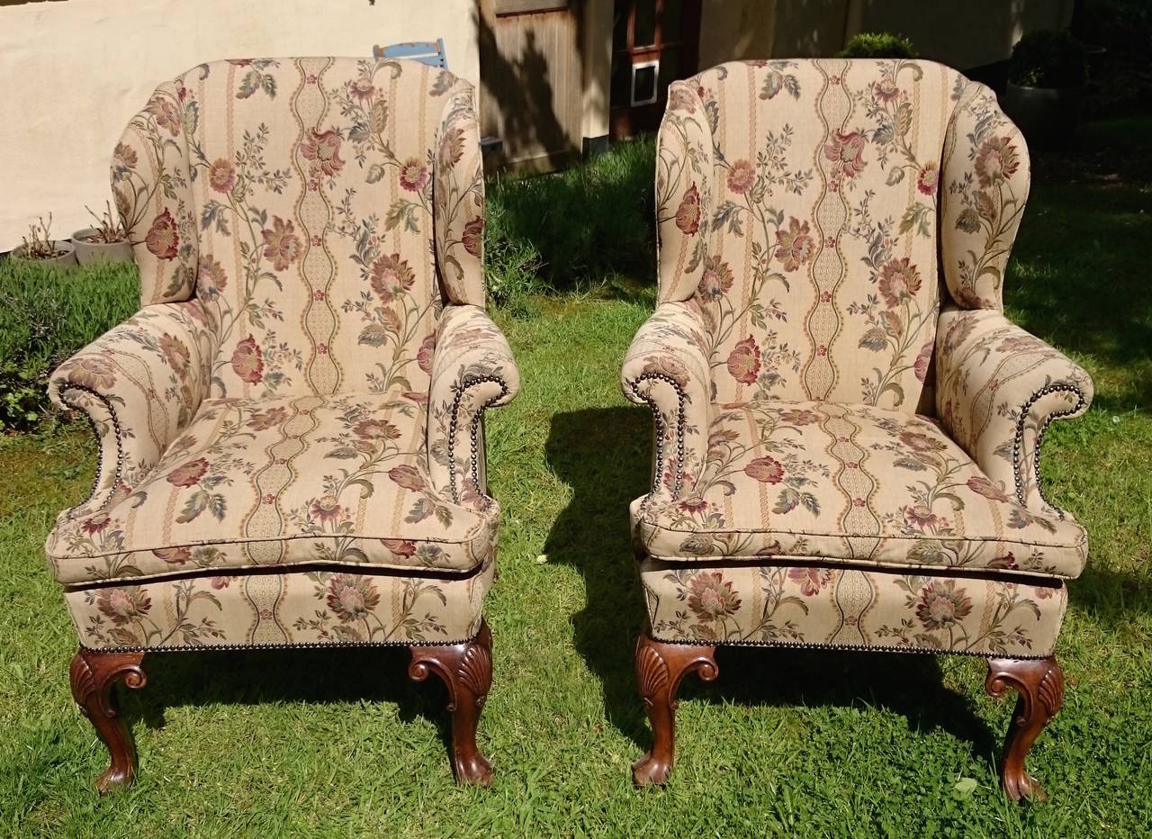 Large pair of 19th century wing armchairs in the manner of the Queen Ann period of cabinet making. True to this design they have walnut cabriole legs with carved shell motif, c-scroll arms and a really generous splay to the back legs. These are