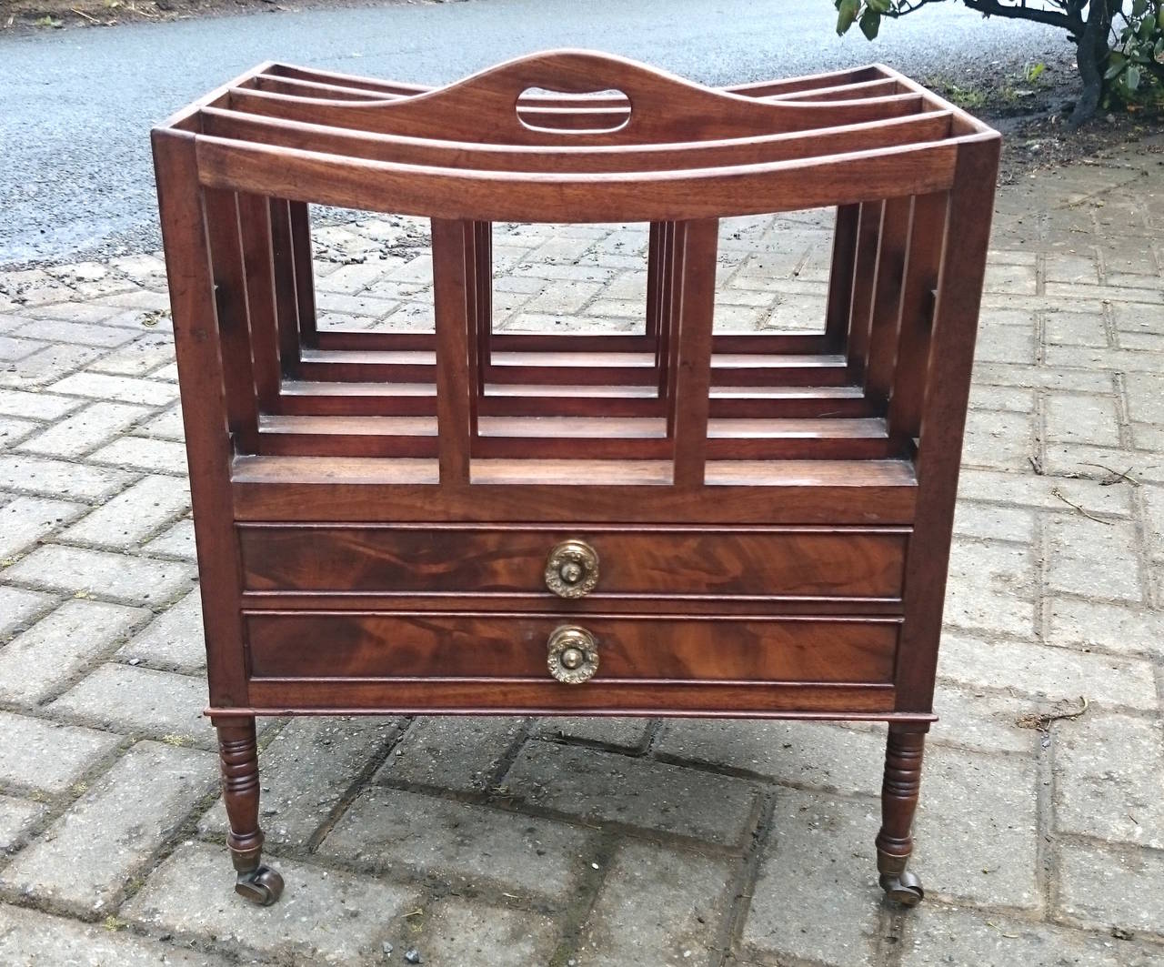 Early 19th century antique canterbury, this canterbury is made of mahogany with flame mahogany drawer fronts. The handles are gilt brass and the turned legs and delicate proportions are typical of the transitional period between George III and