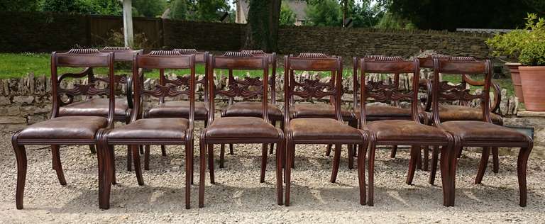 A bakers dozen of antique Regency dining chairs made of the finest mahogany and with nice old leather seats just clinging on. The chairs are in very good condition, but we understand if you want to change the covers.

English circa 1815