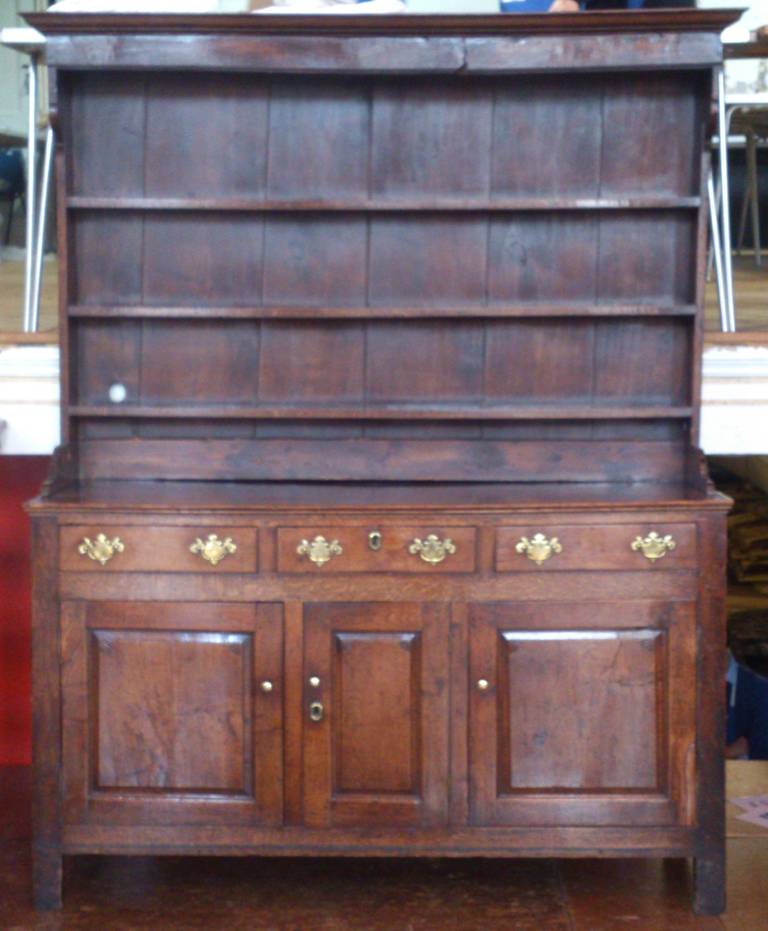 Antique oak dresser from the early 18th century. Usefully this dresser has lots of cupboard space in a compact size and is also very narrow from to back so will not take up too much space.
The colour has faded to a fairly golden brown, which shows