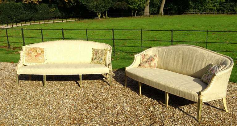 Charming and early near pair of George III period antique sofas standing on tall square taper legs with spade feet. This is a rare opportunity to aquire two so decorative and such similar sofas of this age. The paint is in good condition and shows