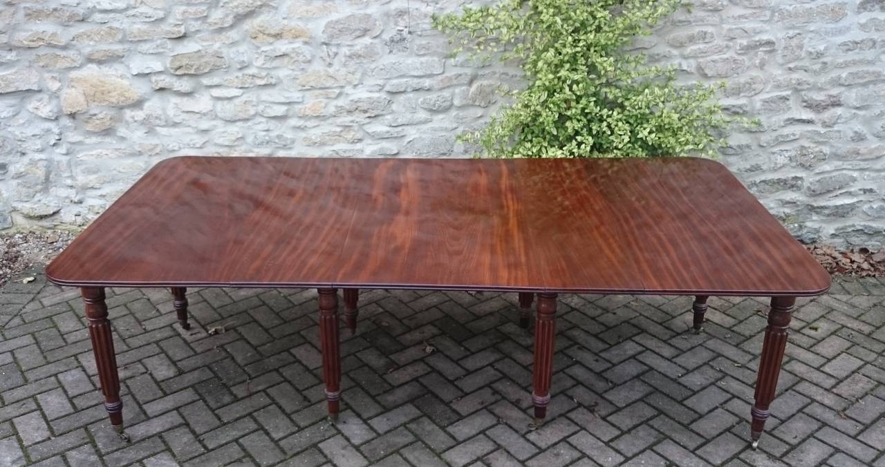 Fine quality extending antique dining table made of good mahogany with interesting grain pattern. This table has legs which are recessed away from the legs of guests and has the ability to split into two side tables very much in the manner of